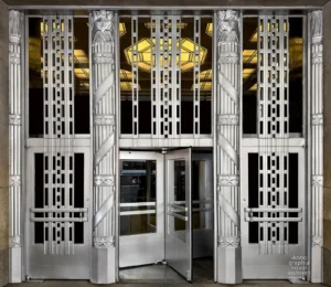 Post Office entrance, 90 Church Street Federal Office Building, New York, 1937. Aluminum grille and POST·OFFICE lettering by Carl Paul Jennewein, barrel vault and chandelier visible beyond.
